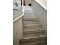 Carpeted staircase with white railings and neutral paint; artwork on the wall at 4363 Pittsfield St, Las Vegas, NV 89115