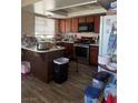 The Kitchen features dark wooden cabinets, laminate countertops, and stainless steel appliances at 5065 Celebrity Cir, Las Vegas, NV 89119