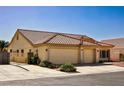 Beautiful single-story home featuring a tile roof, desert landscaping, and a three-car garage at 6016 Bungalow Bay St, Las Vegas, NV 89130