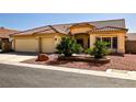 Charming single-story home featuring a tile roof, desert landscaping, and a three-car garage at 6016 Bungalow Bay St, Las Vegas, NV 89130