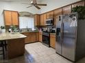 Well-lit kitchen with stainless steel appliances, wood cabinets, and granite countertops at 6361 Copperfield Ave, Las Vegas, NV 89108