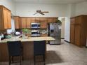 Spacious kitchen with oak cabinets, stainless steel appliances, and a granite countertop island at 6361 Copperfield Ave, Las Vegas, NV 89108