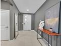Welcoming entryway boasts neutral paint, tiled flooring, and a modern console table with decorative art at 6834 Fallen Rock St, North Las Vegas, NV 89084