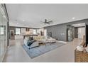 Open-concept living room and kitchen with tile flooring, large sectional, and stainless steel appliances at 6834 Fallen Rock St, North Las Vegas, NV 89084