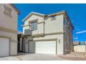 A two-story home featuring an attached two-car garage, complemented by beige siding and crisp, white trim at 6844 Tropicaire St, Las Vegas, NV 89149