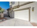 Attached two-car garage featuring a driveway, traditional carriage door, and an exterior sconce at 6844 Tropicaire St, Las Vegas, NV 89149