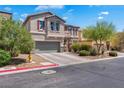 Stucco two-story home featuring desert landscaping, a two-car garage, and a charming tiled roof at 7194 Clear Range Ave, Las Vegas, NV 89178