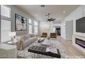 Bright living room with modern decor, large windows, and a cozy fireplace at 7460 Desert Flame Ct, Las Vegas, NV 89149