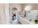 Bathroom featuring double sinks and vanity, with an archway leading to bedroom at 76 Stock Option St # 2, Henderson, NV 89074