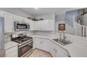 Bright kitchen features white cabinets, stainless steel appliances, and sleek countertops at 76 Stock Option St # 2, Henderson, NV 89074