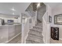 Carpeted staircase with white railing leads to the upper level, bathed in natural light at 76 Stock Option St # 2, Henderson, NV 89074