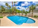 A refreshing pool with a step-down entrance, surrounded by palm trees and desert plants, ideal for relaxation at 7730 Brambly Creek Ct, Las Vegas, NV 89129