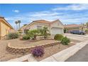Inviting single-story home with desert landscaping, featuring rocks, bushes, and a two-car garage at 7929 Ben Hogan Dr, Las Vegas, NV 89149