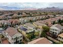 An aerial view of a residential neighborhood featuring desert landscaping, mountain views and diverse home styles at 852 Colina Alta Pl, Las Vegas, NV 89138
