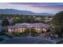 Beautiful single-story home featuring lush landscaping, stone accents, and a circular driveway with mountain views at 8620 W La Madre Way, Las Vegas, NV 89149