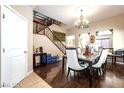 Elegant dining area showcasing hardwood floors, staircase, and decorative chandelier at 9856 Chief Sky St, Las Vegas, NV 89178