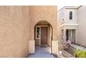 Inviting front entrance featuring an arched entryway and well-maintained facade at 9856 Chief Sky St, Las Vegas, NV 89178