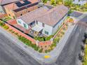 A high angle aerial view shows a home with a patio, green spaces, and a surrounding brick wall at 10025 San Floriano St, Las Vegas, NV 89178