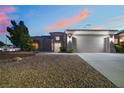 Charming single-story home with a three-car garage, desert landscaping, and sunset at 10901 Fort Valley Ave, Las Vegas, NV 89134