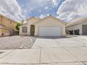 A charming single-story home with a two-car garage and desert landscaping at 1305 Pagentry Dr, North Las Vegas, NV 89031