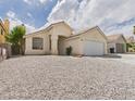 Inviting single-story home featuring desert landscaping, complemented by an attached two-car garage at 1305 Pagentry Dr, North Las Vegas, NV 89031