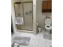 Bathroom featuring a tiled floor, glass shower enclosure, built-in shelf, and toilet at 1461 E Elderberry St, Pahrump, NV 89048