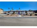 Charming single-story home with a blue door and desert landscaping at 1631 Ottawa Dr, Las Vegas, NV 89169