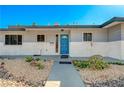 Charming single-story home with a cheerful blue door and desert landscaping at 1631 Ottawa Dr, Las Vegas, NV 89169