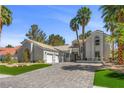 Charming single-story home boasts lush landscaping, palm trees and a three car garage at 2268 Buckingham Ct, Henderson, NV 89074
