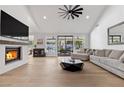 Bright living room featuring hardwood floors, a modern fireplace, and sliding glass doors to the backyard at 2268 Buckingham Ct, Henderson, NV 89074