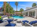 Backyard pool area with a rock waterfall feature and an array of seating areas at 2268 Buckingham Ct, Henderson, NV 89074