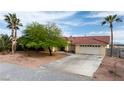 Exterior home showcasing desert landscaping, tile roof, and a two-car garage with a long driveway at 3481 Winery Rd, Pahrump, NV 89048