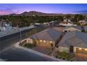 Inviting single-story home with a brick driveway, three-car garage, and meticulously landscaped front yard near tree lined street at 3706 Etendre Ct, Las Vegas, NV 89121