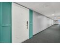 Hallway features carpet flooring with views of the unit's entrance door with teal shutters at 3930 University Center Dr # 603, Las Vegas, NV 89119