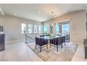 Bright dining area features a modern chandelier, seating for six, and sliding glass doors to a balcony at 414 Tranquil Peak Ct, Henderson, NV 89012