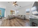 Inviting living room with wood-look floors, neutral furniture, and a modern ceiling fan at 485 Pebble Run Ave, Henderson, NV 89011