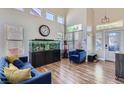 Open-concept living room with vaulted ceilings, wood-look floors, and a large fish tank at 5502 Cinnamon Ave, Las Vegas, NV 89122