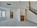 Spacious living room featuring a wet bar and a staircase, adjacent to an opening into the kitchen at 6436 Deadwood Rd, Las Vegas, NV 89108