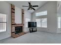 Bright living room featuring high ceilings, a brick fireplace, and large windows with blinds at 6436 Deadwood Rd, Las Vegas, NV 89108