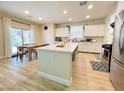 Modern kitchen featuring a center island, stainless steel appliances, and an adjacent dining area with outdoor access at 7083 Seat Wall Rd, Las Vegas, NV 89148