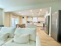 Bright living room with comfortable white sofa, flowing into dining area and kitchen with stainless steel appliances at 7083 Seat Wall Rd, Las Vegas, NV 89148