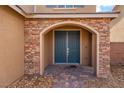Inviting entryway featuring a beautiful stone archway and a modern, dual door entrance at 7107 Calvert Cliffs St, North Las Vegas, NV 89084