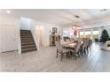 Open-concept living area featuring neutral tones, a staircase, and light wood-look flooring at 7107 Calvert Cliffs St, North Las Vegas, NV 89084