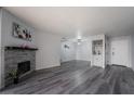 Stylish living room with a decorative stone fireplace, gray wood floors, and a small wet bar at 745 N Royal Crest Cir # 141, Las Vegas, NV 89169