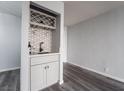 Chic wet bar area with patterned tile backsplash, gray wood floors, and modern fixtures at 745 N Royal Crest Cir # 141, Las Vegas, NV 89169