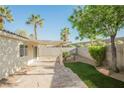 A private backyard is shaded by a covered patio, decorative stone, and mature landscaping at 7754 Pink Ginger St, Las Vegas, NV 89123