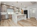 A modern kitchen features a marble waterfall island and stainless steel appliances at 8095 Carpenter Creek Ave, Las Vegas, NV 89113
