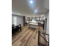 Open-concept kitchen with a large marble island, gray cabinets, and dining table at 8095 Carpenter Creek Ave, Las Vegas, NV 89113