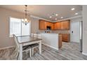 Bright and sunny kitchen featuring a dining table, stainless steel appliances, and wood-look tile flooring at 8152 Satin Carnation Ln, Las Vegas, NV 89166