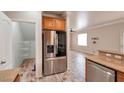 Bright kitchen area featuring stainless steel refrigerator, breakfast bar, and pantry space at 8152 Satin Carnation Ln, Las Vegas, NV 89166